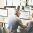 Man at a computer being tutored by a woman
