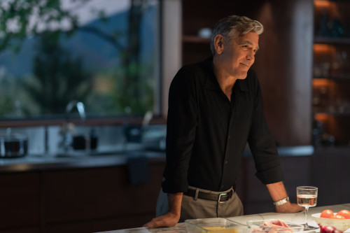 picture from the movie Jay Kelly of George Clooney standing in a darkened kitchen next to a counter