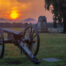 picture of gettysburg at sunset. Cannon and monument in the foreground.