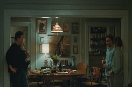 Photo from the movie 'The Invite' Four people sitting at a table talking to one another.